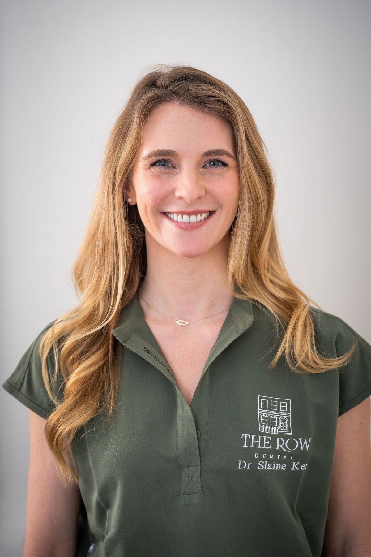 Smiling dentist photographed against a neutral background